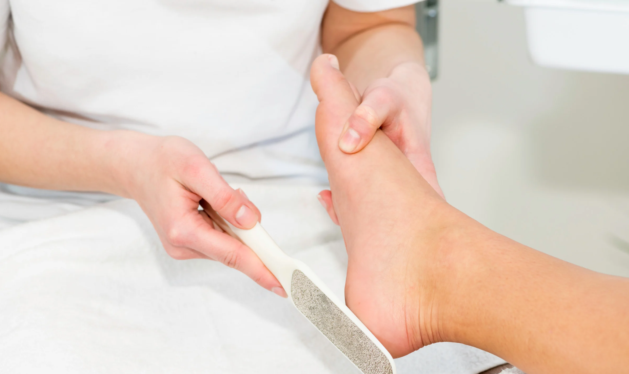 A nail technician filing the heel during a pedicure treatment, one of our expert services on the nail salon menu