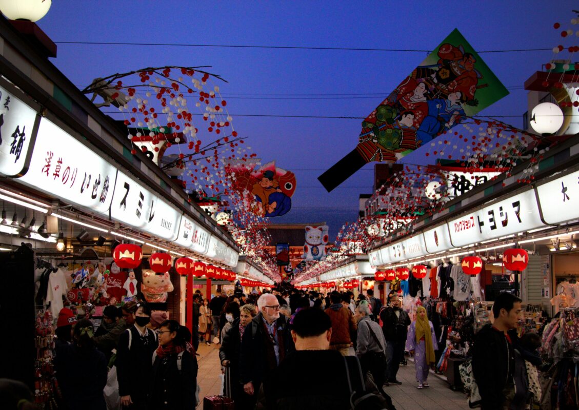 Tourists walking through a busy market street in Japan