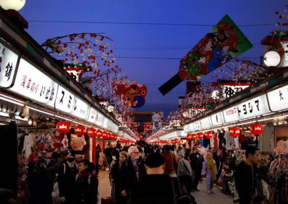 Tourists walking through a busy market street in Japan